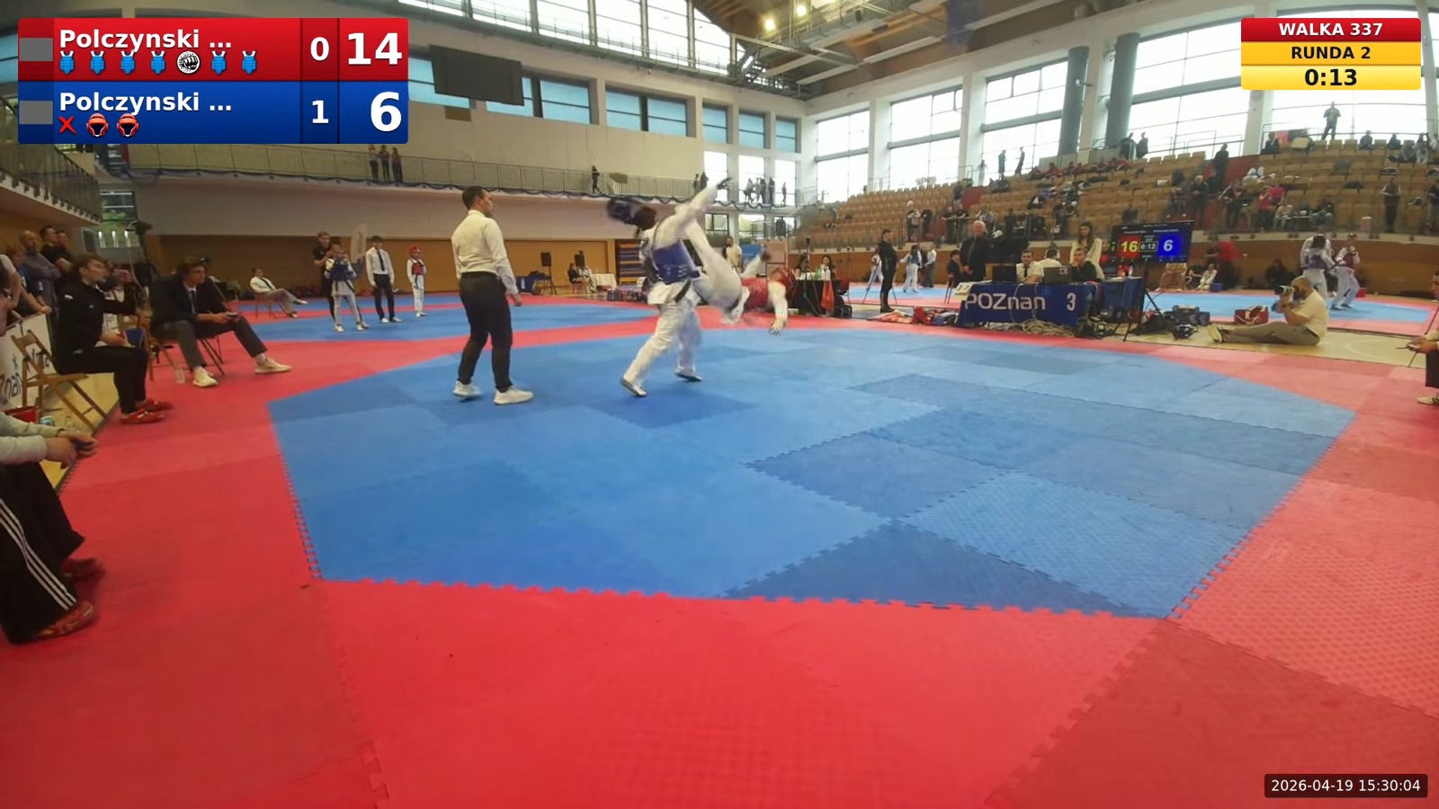 A real frame from a Dollyo360 YouTube stream at Poland's Cup 2026: a head kick scores, live scores on screen. Click to play the clip.